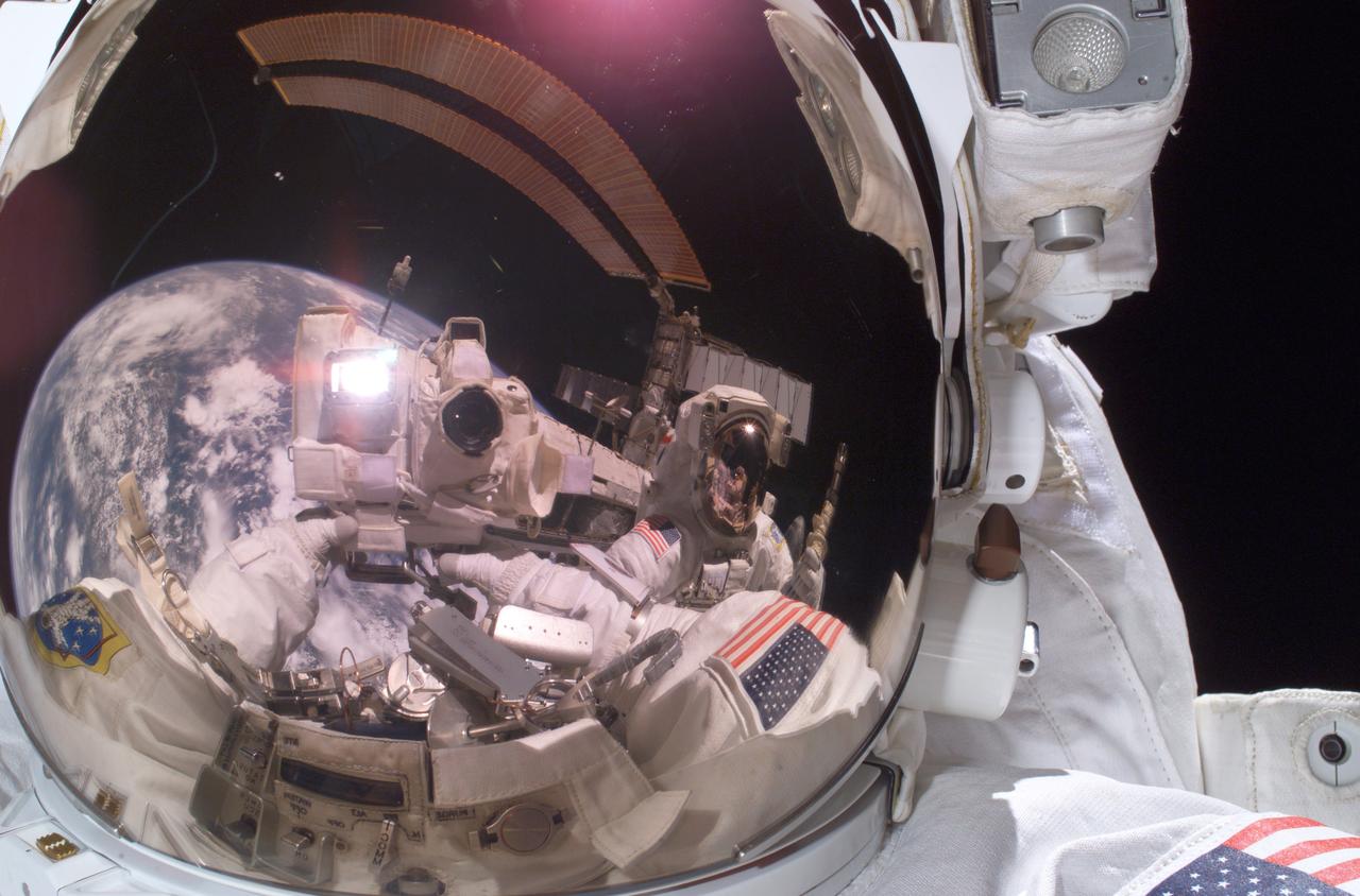 Astronaut Michael E. Fossum, STS-121 mission specialist, used a digital still camera to expose a photo of his helmet visor during a session of extravehicular activity (EVA) while Space Shuttle Discovery was docked with the International Space Station (ISS). Also visible in the visor reflections are fellow space walker Piers J. Sellers, mission specialist, Earth's horizon, and a station solar array. During its 12-day mission, this utilization and logistics flight delivered a multipurpose logistics module (MPLM) to the ISS with several thousand pounds of new supplies and experiments. In addition, some new orbital replacement units (ORUs) were delivered and stowed externally on the ISS on a special pallet. These ORUs are spares for critical machinery located on the outside of the ISS. During this mission the crew also carried out testing of Shuttle inspection and repair hardware, as well as evaluated operational techniques and concepts for conducting on-orbit inspection and repair.