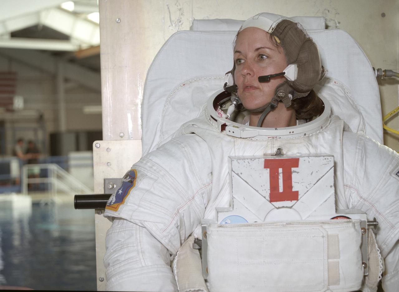 This close-up of astronaut and mission specialist Kathryn Thornton readies herself for submersion into the water in the Marshall Space Flight Center (MSFC) Neutral Buoyancy Simulator (NBS) where she is participating in a training session for the STS-61 mission. The NBS provided the weightless environment encountered in space needed for testing and the practices of Extravehicular Activities (EVA). Launched on December 2, 1993 aboard the Space Shuttle Orbiter Endeavor, STS-61 was the first Hubble Space Telescope (HST) serving mission. During the 2nd EVA of the mission, Thornton, along with astronaut and mission specialist Thomas Akers, performed the task of replacing the solar arrays. The EVA lasted 6 hours and 35 minutes.