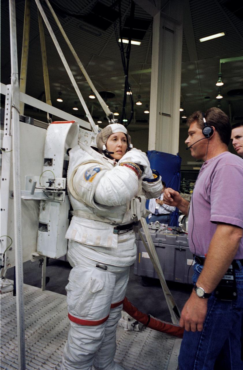 Astronaut Kathryn Thornton, payload commander for the STS-73 mission, attired in a high fidelity training version of the Extravehicular Mobility Unit (EMU) space suit, prepares to go underwater in the Johnson Space Center’s (JSC) Weightless Environment Training Facility (WET-F). The STS-73 mission was the second flight of the United States Microgravity Laboratory (USML-2), managed by scientists and engineers from the Marshall Space Flight Center.