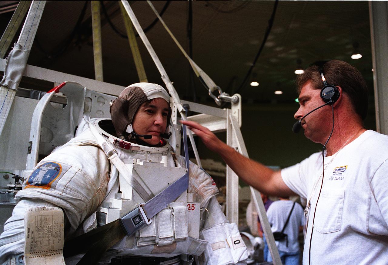 Astronaut and mission specialist, Linda Godwin, checks communications systems before submersion into a 25 ft deep pool at the Johnson Space Center’s (JSC) Weightless Environment Training Facility (WET-F). Wearing a high fidelity training version of the Extravehicular Mobility Unit (EMU) space suit, Godwin simulated STS-76 Extravehicular Activity (EVA) chores in the pool. Launched aboard the Space Shuttle Atlantis in March of 1996, STS-76 marked the third U.S. Shuttle-Mir docking during which Godwin, along with astronaut and mission specialist Michael R. ( Rich) Clifford, performed the first Extravehicular Activity (EVA) during Mir-Shuttle docked operations.     