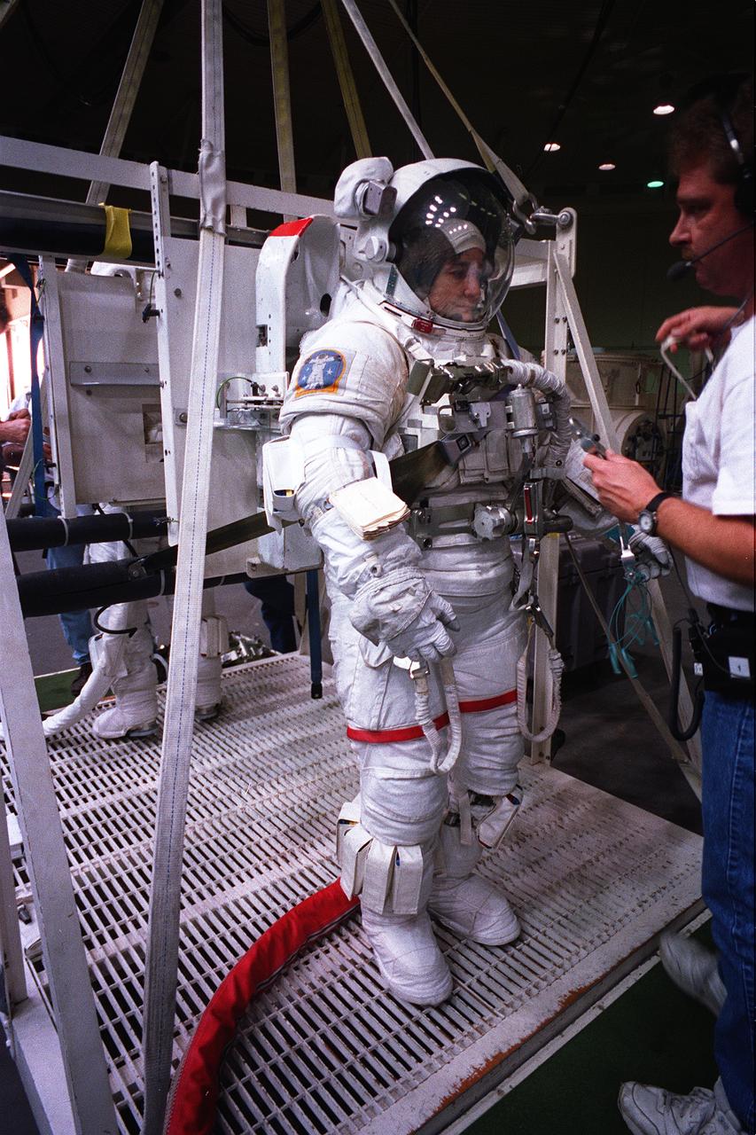 Astronaut and mission specialist, Linda Godwin, makes a final check of her respiration system before submersion into a 25 ft deep pool at the Johnson Space Center’s (JSC) Weightless Environment Training Facility (WET-F). Wearing a high fidelity training version of the Extravehicular Mobility Unit (EMU) space suit, Godwin simulated STS-76 Extravehicular Activity (EVA) chores in the pool. Launched aboard the Space Shuttle Atlantis in March of 1996, STS-76 marked the third U.S. Shuttle-Mir docking during which Godwin, along with astronaut and mission specialist Michael R. (Rich) Clifford, performed the first Extravehicular Activity (EVA) during Mir-Shuttle docked operations.     