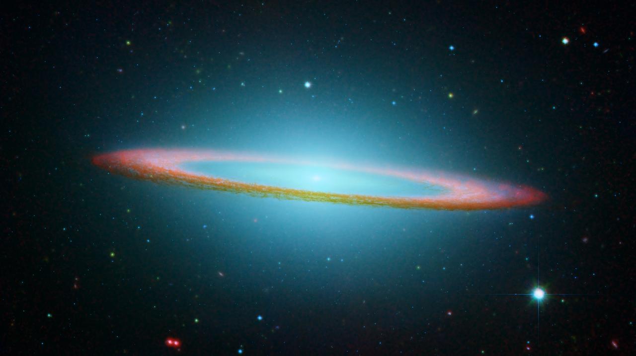 The razor sharp eye of the Hubble Space Telescope (HST) easily resolves the Sombrero galaxy, Messier 104 (M104). 50,000 light-years across, the galaxy is located 28 million light-years from Earth at the southern edge of the rich Virgo cluster of galaxies. Equivalent to 800 billion suns, Sombrero is one of the most massive objects in that group. The hallmark of Sombrero is a brilliant white, bulbous core encircled by the thick dust lanes comprising the spiral structure of the galaxy. As seen from Earth, the galaxy is tilted nearly edge-on. We view it from just six degrees north of its equatorial plane. This rich system of globular clusters is estimated to be nearly 2,000 in number which is 10 times as many as in our Milky Way galaxy. Similar to the clusters in the Milky Way, the ages range from 10-13 billion years old. Embedded in the bright core of M104 is a smaller disk, which is tilted relative to the large disk. The HST paired with the Spitzer infrared telescope, offers this striking composite capturing the magnificence of the Sombrero galaxy. In the Hubble view, the galaxy resembles a broad-rimmed Mexican hat, whereas in the Spitzer striking infrared view, the galaxy looks more like a bulls eye. The full view provided by Spitzer shows the disk is warped, which is often the result of a gravitational encounter with another galaxy, and clumpy areas spotted in the far edges of the ring indicate young star forming regions. Spitzer detected infrared emission not only from the ring, but from the center of the galaxy as well, where there is a huge black hole believed to be a billion times more massive than our Sun. The Marshall Space Flight Center (MSFC) had responsibility for design, development, and construction of the HST.