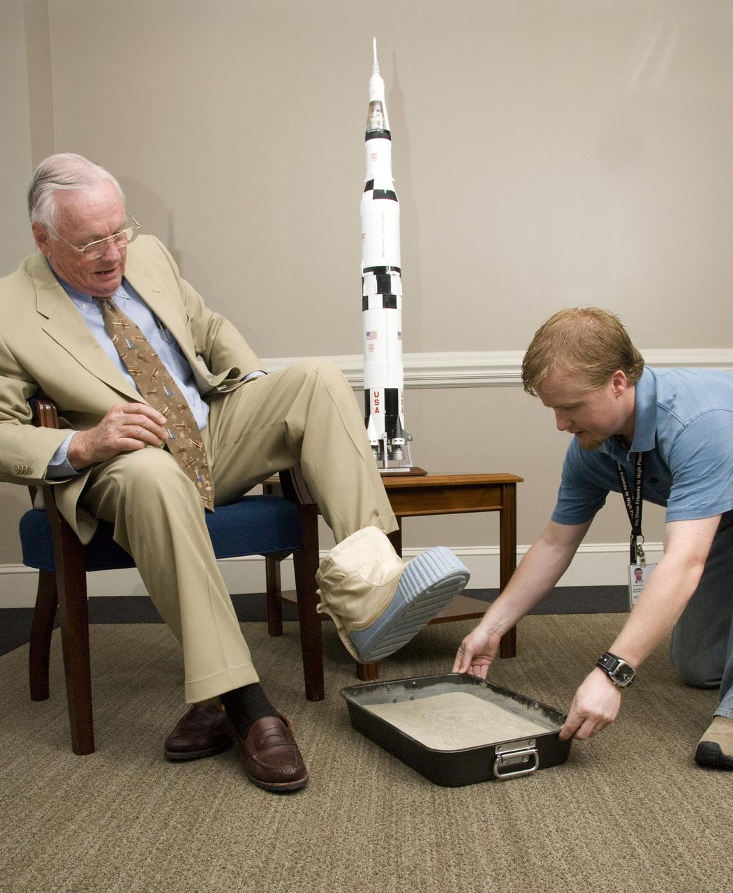 Among several other NASA dignitaries, former astronaut Neil A. Armstrong visited the Marshall Space Flight Center (MSFC) in attendance of the annual NASA Advisory Council Meeting. While here, Mr. Armstrong was gracious enough to allow the casting of his footprint. This casting will join those of other astronauts on display at the center. Armstrong was first assigned to astronaut status in 1962. He served as command pilot for the Gemini 8 mission, launched March 16, 1966, and performed the first successful docking of two vehicles in space. In 1969, Armstrong was commander of Apollo 11, the first manned lunar landing mission, and gained the distinction of being the first man to land a craft on the Moon and the first man to step on its surface. Armstrong subsequently held the position of Deputy Associate Administrator for Aeronautics, NASA Headquarters Office of Advanced Research and Technology, from 1970 to 1971. He resigned from NASA in 1971. Pictured with Armstrong is MSFC employee Daniel McFall, who assisted with the casting procedure.