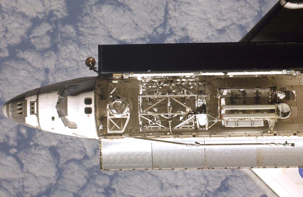 This nadir view of the STS-117 mission Space Shuttle Atlantis, taken by the Expedition 15 crew aboard the International Space Station (ISS), occurred just before the two spacecraft linked up in Earth orbit.  Berthed in the cargo bay are the 17.8 ton second and third (S3 and S4) truss segments ready for installment. STS-117 mission objectives included the addition of S3 and S4 with Photovoltaic Radiator (PVR), the deployment of the third set of solar arrays, and the retraction of the P4 starboard solar array wing and one radiator. 