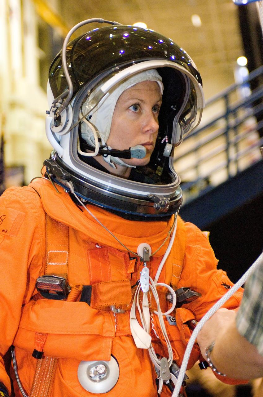 Tracy E. Caldwell, STS-118 astronaut and mission specialist, participates in a training session on the usage of a special device, used to lower oneself from a troubled shuttle, in the Space Vehicle Mockup Facility at the Johnson Space Center. Caldwell is wearing a training version of her shuttle launch and entry suit.