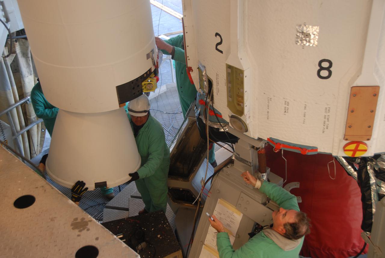 VANDENBERG AIR FORCE BASE, Calif. --  On Space Launch Complex 2 at Vandenberg Air Force Base in California, workers maneuver the solid rocket motor, or SRM, next to the Delta II first stage inside the mobile service tower. The Delta II is the launch vehicle for the OSTM_Jason-2 spacecraft.  The OSTM, or Ocean Topography Mission, on the Jason-2 satellite is a follow-on to Jason-1. It will take oceanographic studies of sea surface height into an operational mode for continued climate forecasting research and science and industrial applications.  This satellite altimetry data will help determine ocean circulation, climate change and sea-level rise. OSTM is a joint effort by the National Oceanic and Atmospheric Administration, NASA, France’s Centre National d’Etudes Spatiales and the European Meteorological Satellite Organisation. OSTM_Jason-2 will be launched aboard a United Launch Alliance Delta II 7320 from Vandenberg on June 15.  Photo credit: NASA_Dan Liberotti