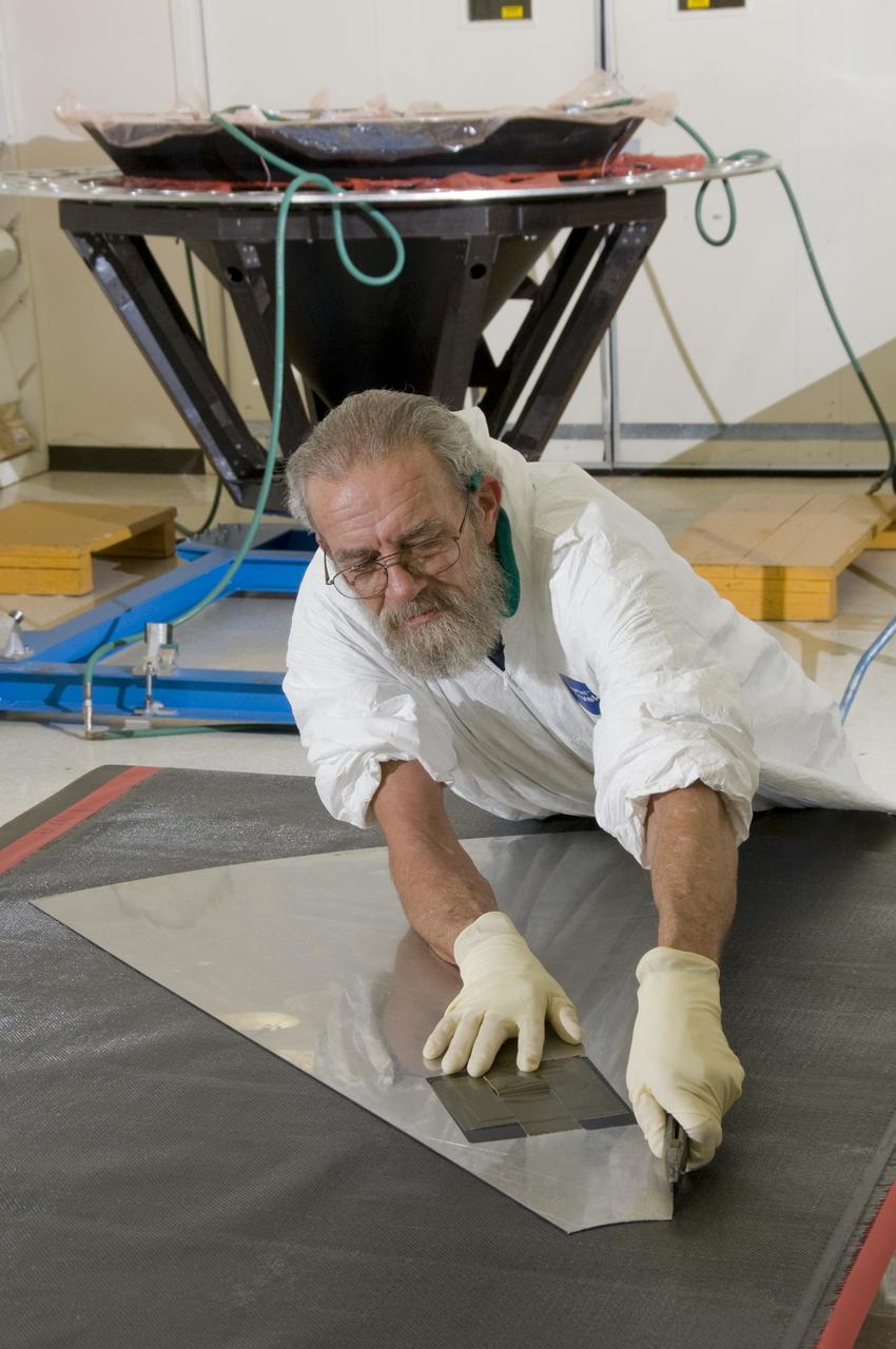 ED KIRCH, A LOCKHEED MARTIN TECHNICIAN, CUTS A PATTERN FROM COMPOSITE MATERIAL THAT WILL BE PLACED IN A MOLD TO BUILD A SPACE SHUTTLE EXTERNAL TANK COMPOSITE NOSE CONE.