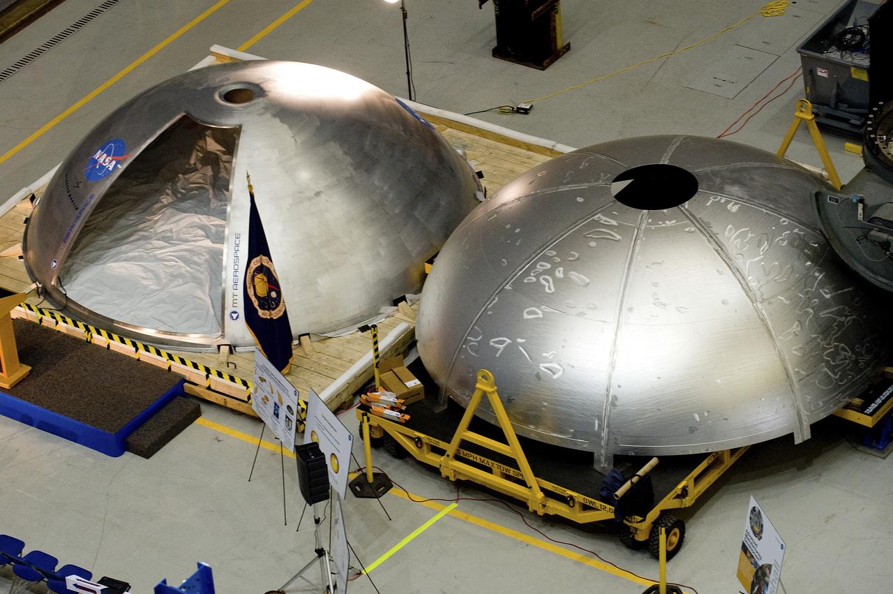 THE LEFT DOME WAS CREATED USING THE NEW MANUFACTURING PROCESSES AND ELIMINATES AT LEAST EIGHT MAJOR WELDS. THE WELD DEMARCATION LINES ARE VISIBLE ON THE TRADITIONAL FABRICATED TANK DONE ON THE RIGHT. THIS WAS PART OF THE FRICTION STIR COMMON BULKHEAD DOME UNVEILING CEREMONY IN BUILDING 4755