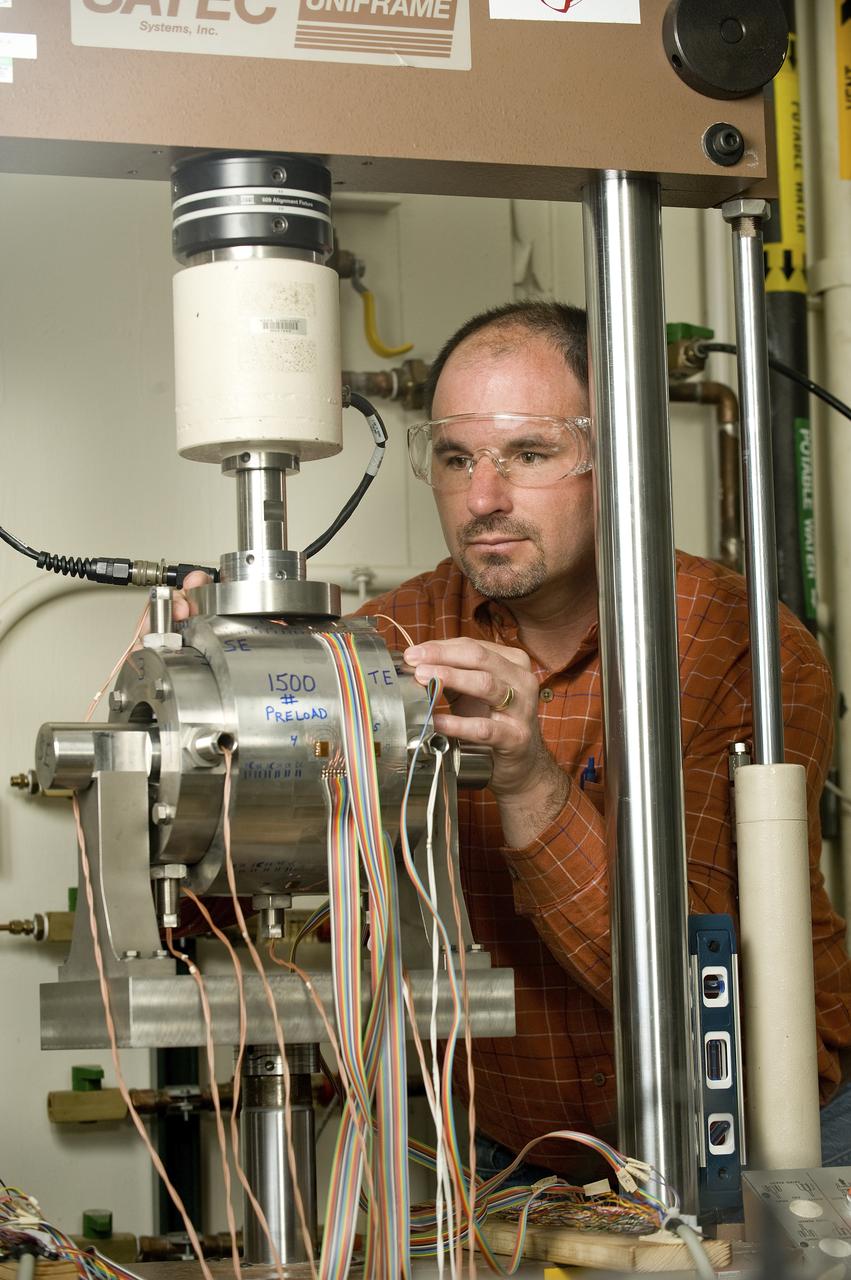 HORACE STORNG (AEROSPACE ENGINEER, ER31 PROPULSION TURBOMACHINERY DESIGN & DEVELOPMENT BRANCH) ADJUSTS A UNIQUE MECHANICAL TEST SETUP THAT MEASURES STRAIN ON A SINGLE SAMPLE, USING TWO DIFFERENT TECHNIQUES AT THE SAME TIME. THE TEST FIXTURE HOLDS A SPECIMEN THAT REPRESENTS A LIQUID OXYGEN (LOX) BEARING FROM THE J2-X ENGINE