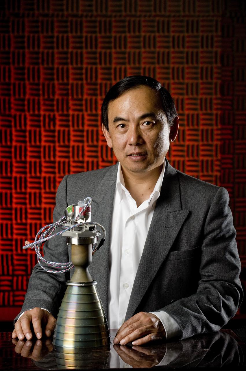 HUU TRINH POSES WITH A HYPERGOLIC BI-PROPELLANT THRUSTER FOR A POTENTIAL APPLICATION ON FUTURE ROBOTIC LUNAR SPACECRAFTS.  