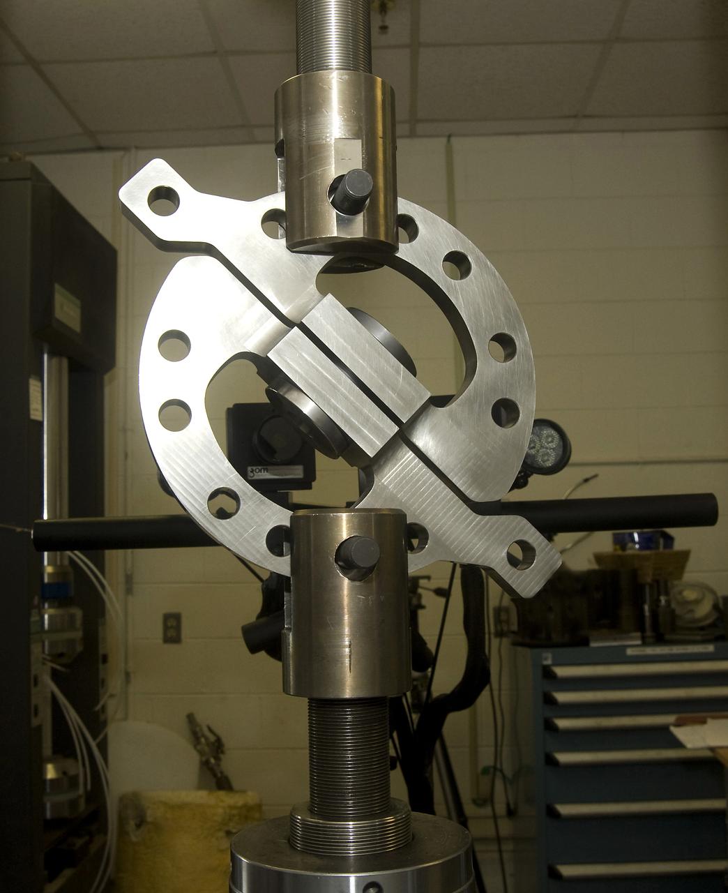 DEVELOPMENT TESTING BEING CONDUCTED AT THE REQUEST OF THE MSFC DYNAMICS, LOADS, AND STRENGTH BRANCH (EV31) TO STUDY THE FAILURE BEHAVIOR OF FASTENERS SUBJECTED TO COMBINED SHEAR AND TENSION LOADING.  THE DATA FROM THIS TESTING WILL BE USED TO DEVELOP APPROPRIATE STRUCTURAL ANALYSIS METHODS AS PART OF A FASTENER STANDARDS EFFORT SPONSORED BY THE NASA ENGINEERING SAFETY CENTER (NESC).  THE TEST FIXTURE WAS DESIGNED AND FABRICATED THROUGH THE MSFC MECHANICAL FABRICATION BRANCH (ES23).  THE TESTING ORGANIZATION IS THE MSFC MATERIALS TEST BRANCH (EM10).  