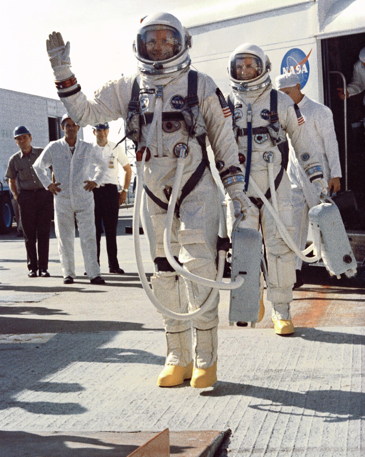 Gemini-8 Astronauts Neil A. Armstrong and David R. Scott smile and wave to the crowd as they walk away from the transfer van at Complex 19, Cape Kennedy prior to boarding their spacecraft.