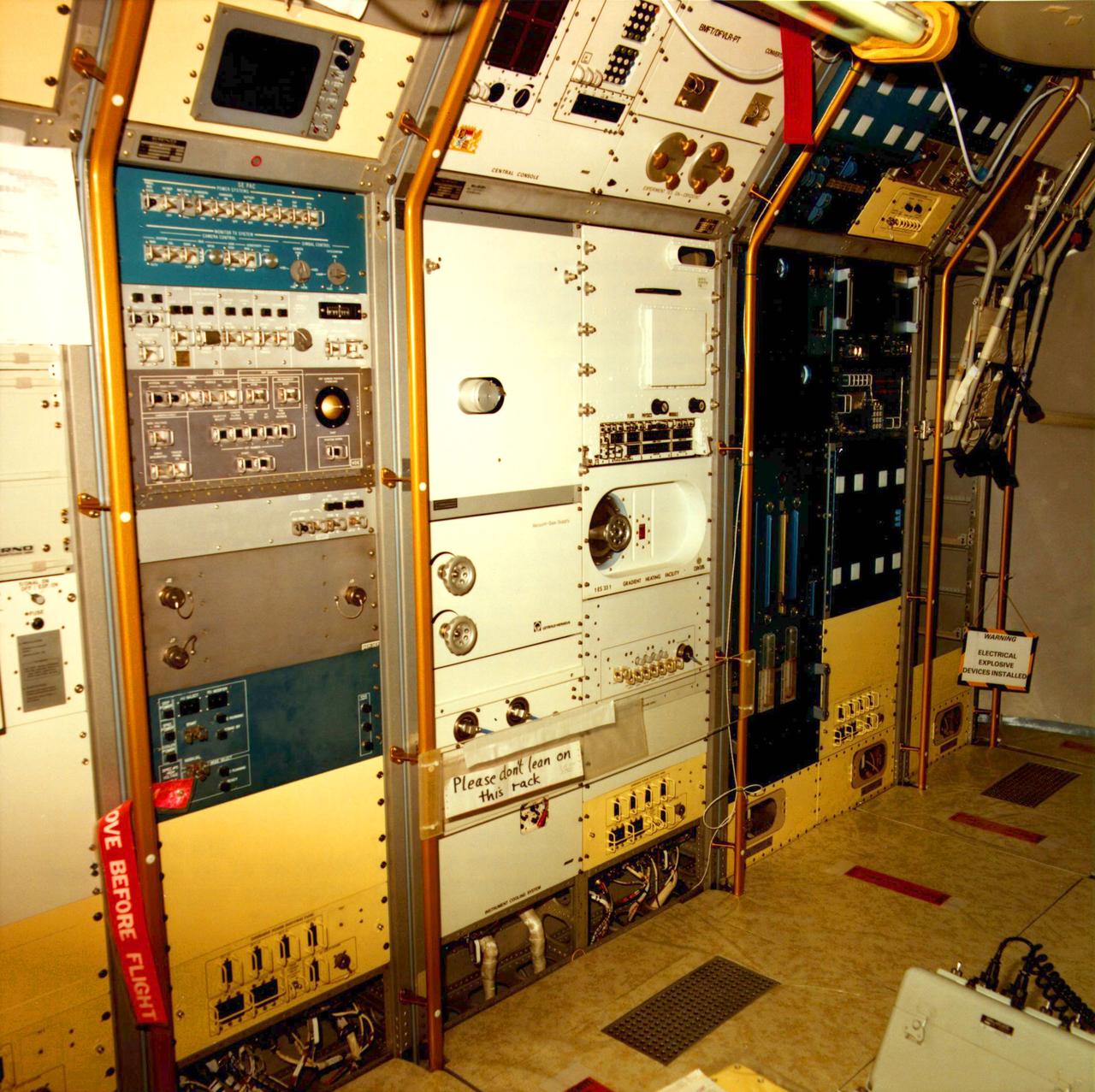 Interior view of Spacelab 1 to show layout of equipment and astronauts testing tools. Operations Checkout (O C) Building located at KSC.