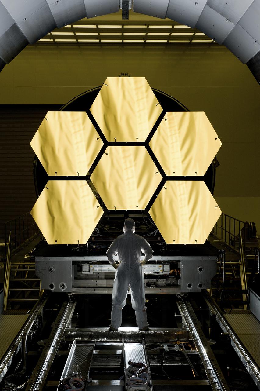 ERNIE WRIGHT STANDS NEAR THE JAMES WEBB SPACE TELESCOPE MIRRORS AS THEY SIT JUST OUTSIDE THE TESTING CHAMBER IN THE XRAY CALIBRATION FACILITY AT MSFC
