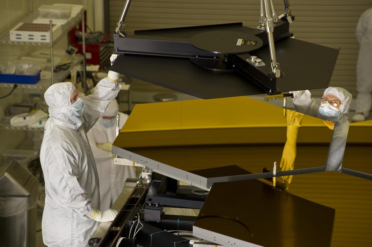 BALL ENGINEERS DISMANTLE ARRAY OF SIX GOLD-PLATED JAMES WEBB SPACE TELESCOPE MIRRORS FOR TRANSPORT TO BALL AEROSPACE AFTER CRYOGENIC TESTING AT MARSHALL'S X-RAY AND CRYOGENIC FACILITY.