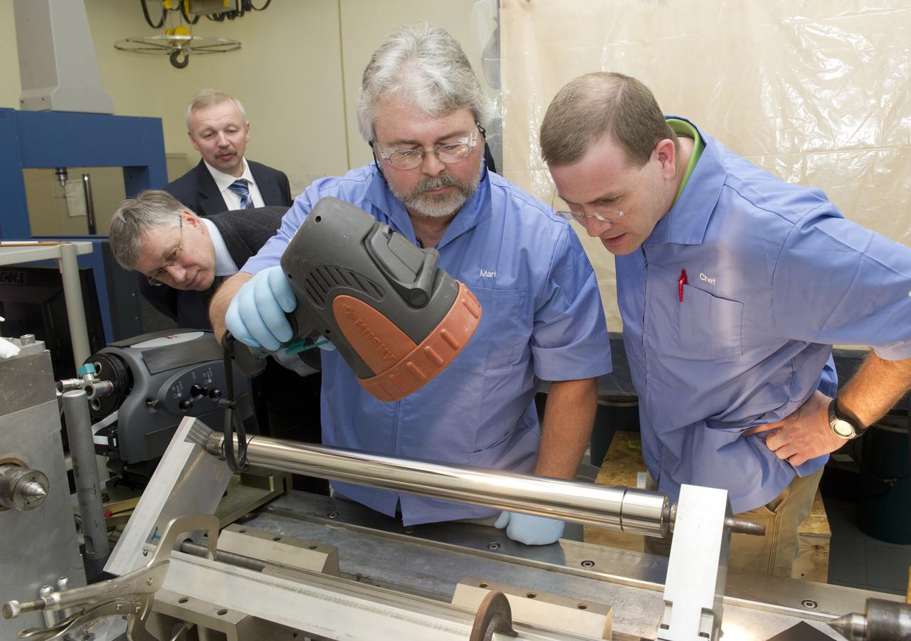 (L TO R) DR. VIKTOR VORON AND DR. MIKHAIL PAVLINSKIY WATCH AS MARK YOUNG AND CHET SPEEGLE CONDUCT BRIGHT LIGHT INSPECTION OF MIRROR MANDREL IN MARSHALL'S OPTICAL INSPECTION LAB.