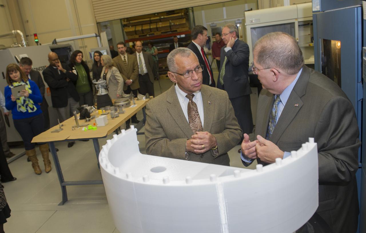 NASA ADMINISTRATOR CHARLES BOLDEN, LEFT, TALKS WITH FRANK LEDBETTER, CHIEF OF THE NONMETALLIC MATERIALS AND MANUFACTURING DIVISION AT MARSHALL, ABOUT A PART OF A PROTOTYPE FOR THE CORE STAGE-TO-BOOSTER ATTACH FITTING DURING BOLDEN'S FEB. 22 VISIT TO THE NATIONAL CENTER FOR ADVANCED MANUFACTURING RAPID PROTOTYPING FACILITY AT MARSHALL. DURING HIS TOUR, BOLDEN WATCHED RESEARCHERS EMPLOY A 3-D PRINTING PROCESS CALLED "SELECTIVE LASER MELTING" TO CREATE COMPLEX PARTS FOR THE J-2X AND RS-25 ROCKET ENGINES -- WITHOUT WELDING.