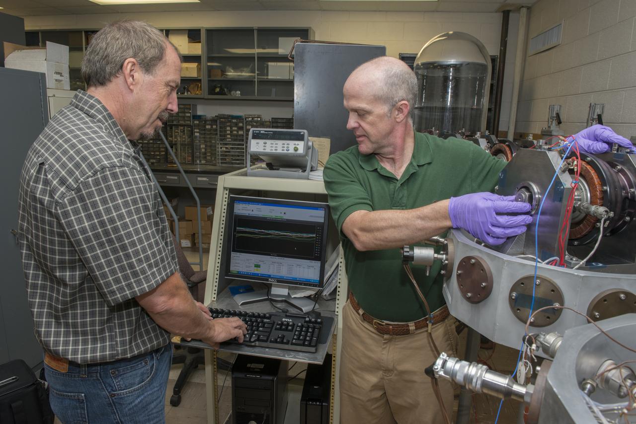NASA ENGINEERS LEWIS “CHIP” MOORE AND TIM JETT STUDYING BALL BEARING DATA