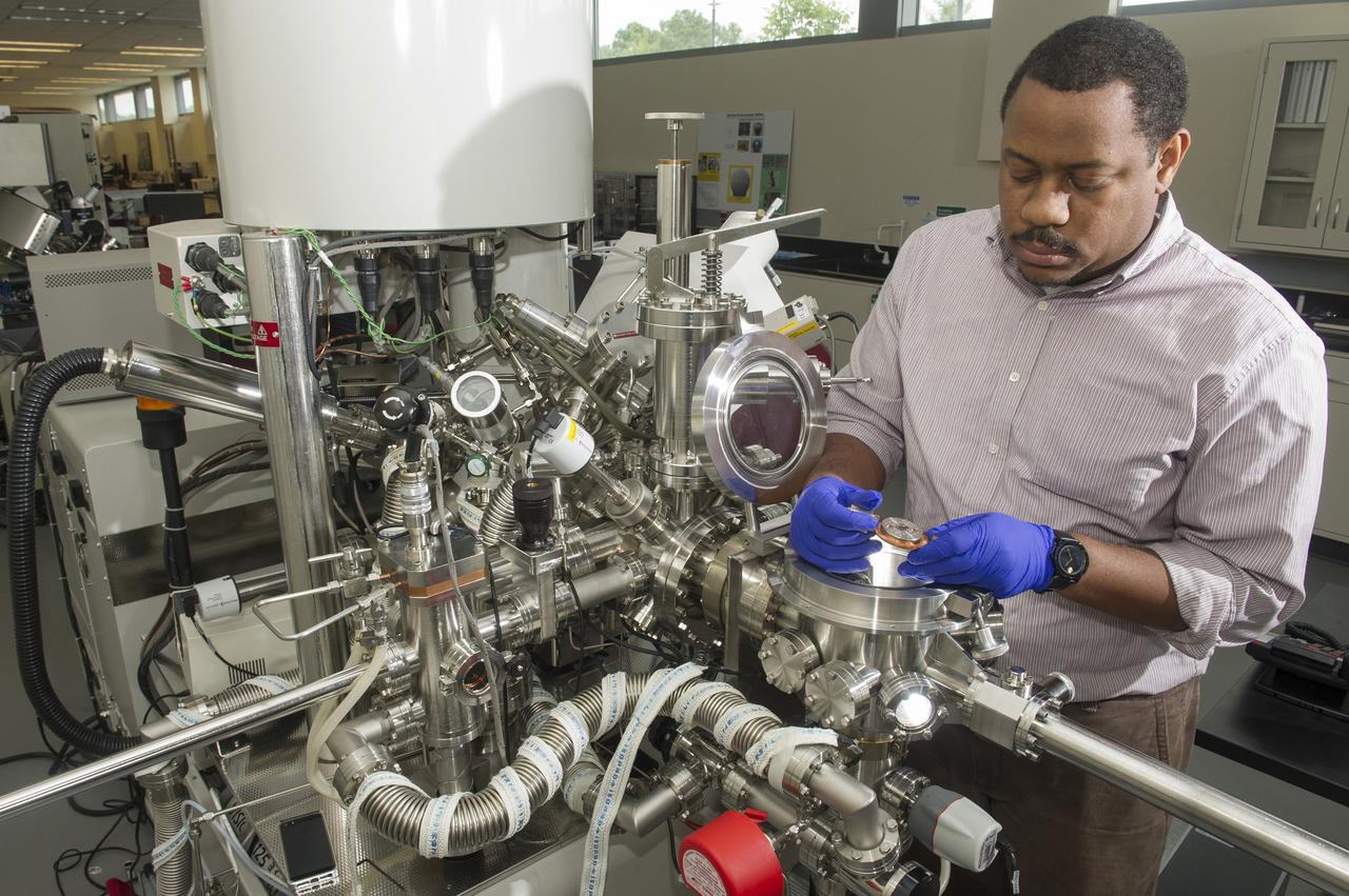 ARTHUR BROWN (AST, AEROSPACE METALLIC MATERIALS) LOADS A CERAMIC COATED SILICON WAFER INTO A KRATOS (ELECTRON SPECTROSCOPY FOR CHEMICAL ANALYSIS) TO PERFORM X-RAY PHOTOELECTRON SPECTROSCOPY (XPS). XPS IS A TECHNIQUE THAT ANALYZES THE SURFACE CHEMISTRY OF A SAMPLE BY IRRADIATING IT WITH X-RAYS AND MEASURING THE NUMBER AND KINETIC ENERGY OF ELECTRON THAT ESCAPE.