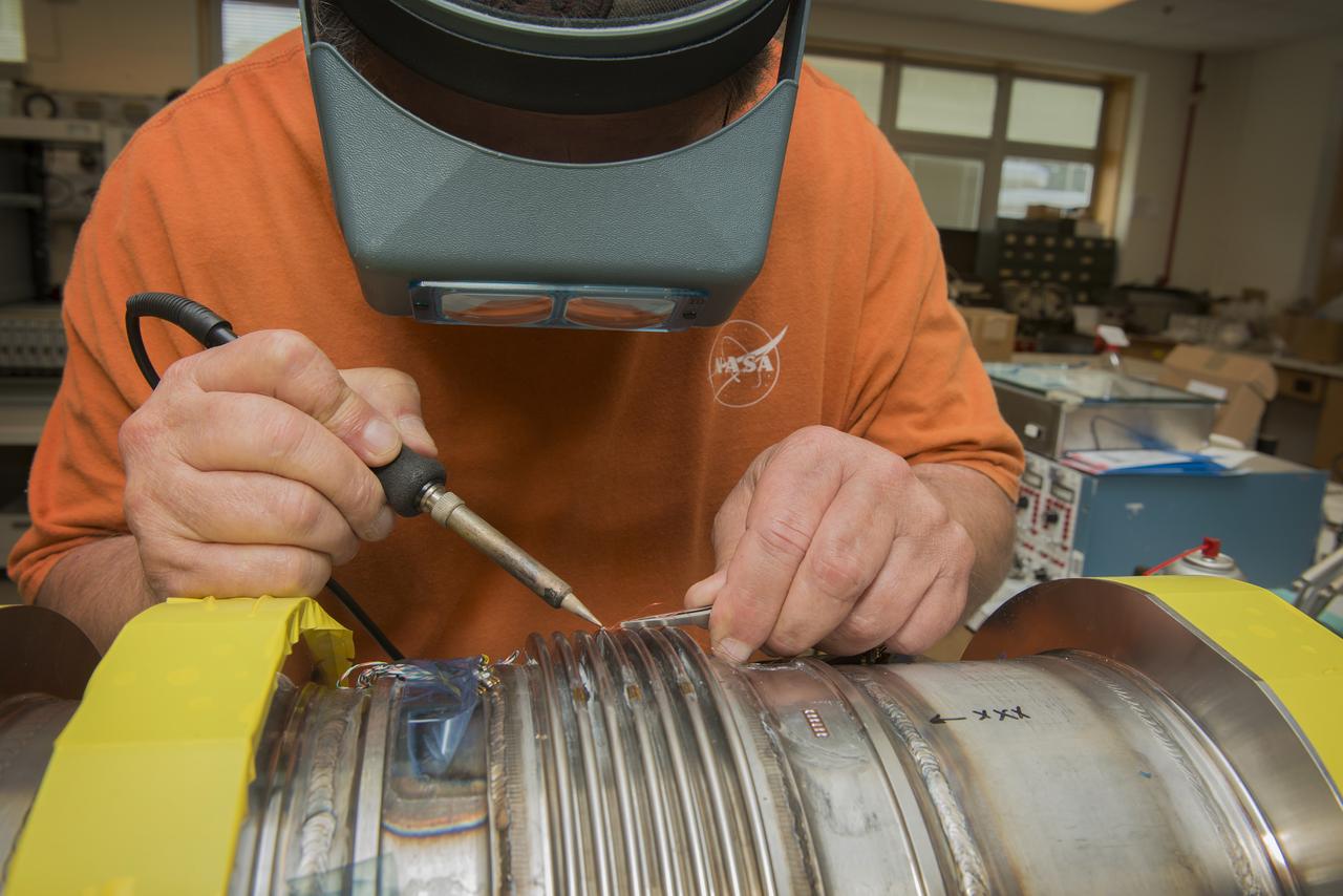 JOE MIRANDY, ET20, PREPARES SENSORS ON THE POGO Z- BAFFLE AND BELLOWS PRIOR TO FLOW TESTING. THE SENSORS WILL MEASURE VIBRATION AS FUEL FLOWS THROUGH THE TUBE AND BAFFLE.