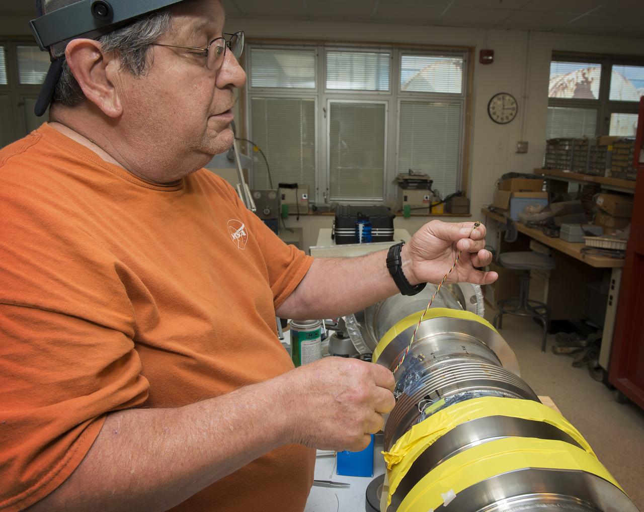 JOE MIRANDY, ET20, PREPARES SENSORS ON THE POGO Z- BAFFLE AND BELLOWS PRIOR TO FLOW TESTING. THE SENSORS WILL MEASURE VIBRATION AS FUEL FLOWS THROUGH THE TUBE AND BAFFLE.