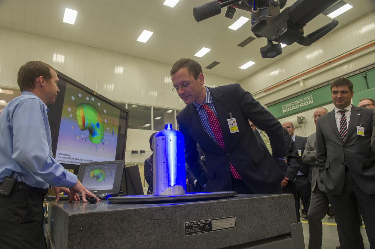MSFC MECHANICAL ENGINEER BRIAN WEST, (L), DEMONSTRATES STRUCTURED LIGHT SCANNING PROCESS TO MEMBERS OF THE  BREMEN, GERMANY, BUSINESS DELEGATION WHO VISITED MARSHALL RECENTLY. SENATOR MARTIN GÜNTHNER, MINISTRY OF ECONOMIC AFFAIRS, LABOUR AND PORTS (CENTER) VIEWS THE PRESSURE VESSEL BEING SCANNED.  AT RIGHT IS BERND SCHMELING, SENIOR MANAGER PROCUREMENT, AIRBUS OPERATIONS GMBH 