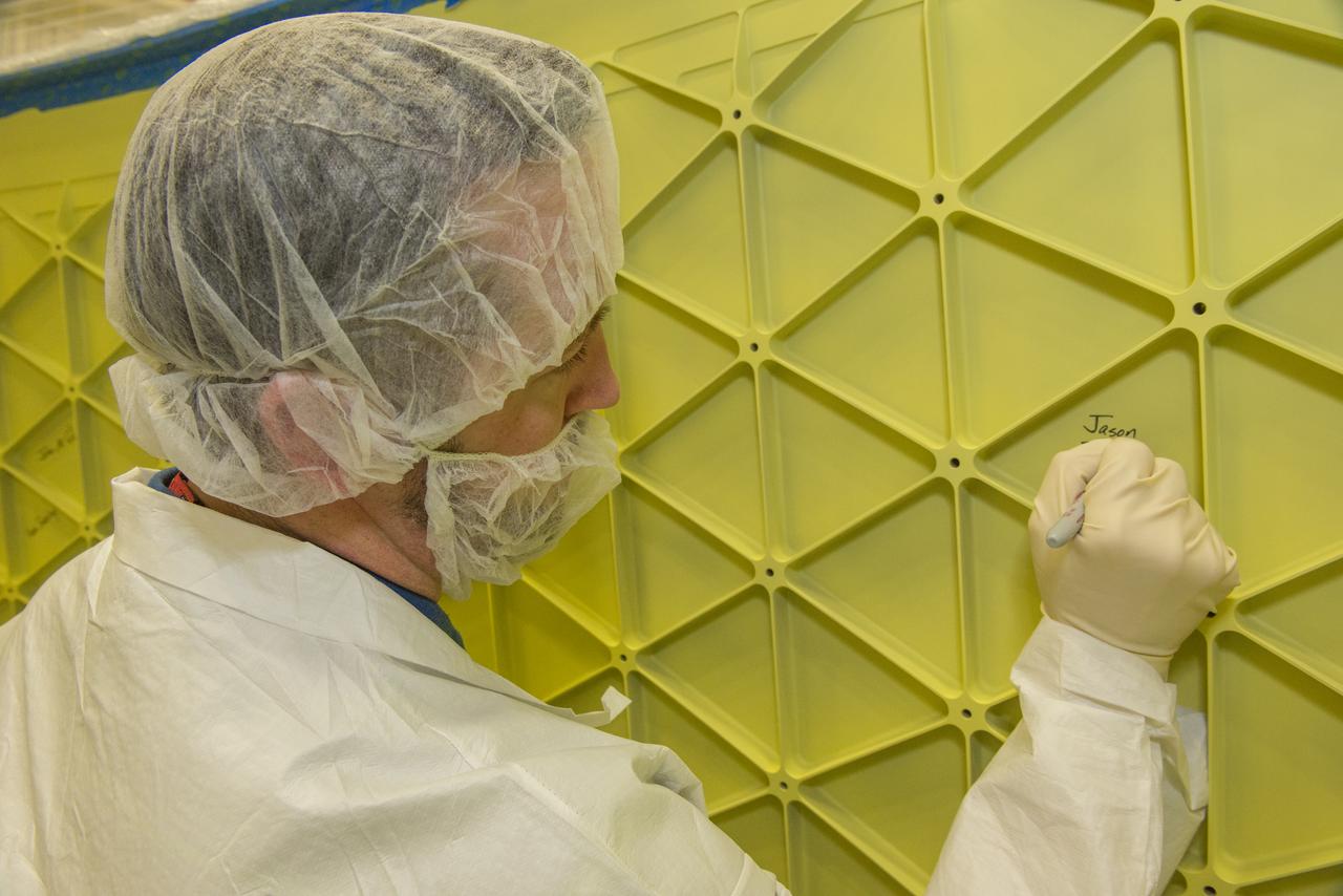 JASON ELDRIDGE, AN ERC INCORPORATED EMPLOYEE SUPPORTING THE MATERIALS & PROCESSES LABORATORY AT NASA'S MARSHALL SPACE FLIGHT CENTER, SIGNS HIS NAME ON THE INTERIOR OF THE ADAPTER THAT WILL CONNECT THE ORION SPACECRAFT TO A UNITED LAUNCH ALLIANCE DELTA IV ROCKET FOR EXPLORATION FLIGHT TEST (EFT)-1. MARSHALL CENTER TEAM MEMBERS WHO WERE INVOLVED IN THE DESIGN, CONSTRUCTION AND TESTING OF THE ADAPTER HAD THE OPPORTUNITY TO AUTOGRAPH IT BEFORE THE HARDWARE IS SHIPPED TO NASA'S KENNEDY SPACE CENTER IN FEBRUARY. ELDRIDGE WAS ON A TEAM THAT PERFORMED ULTRASONIC INSPECTIONS ON THE ADAPTER'S WELDS -- ENSURING THEY ARE STRUCTURALLY SOUND. EFT-1, SCHEDULED FOR 2014, WILL PROVIDE EARLY EXPERIENCE FOR NASA SPACE LAUNCH SYSTEM (SLS) HARDWARE AHEAD OF THE ROCKET'S FIRST FLIGHT IN 2017. 