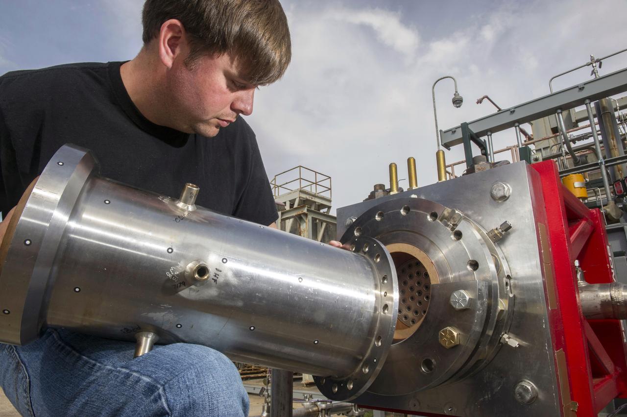 1. ENGINEERS AND TECHNICIANS PREPARE FOR AN UPCOMING HOT-FIRE TEST OF A ROCKET INJECTOR MANUFACTURED USING ADDITIVE MANUFACTURING, OR 3-D PRINTING…RANDALL MCALLISTER, INFOPRO TECHNICIAN, FITS NOZZLE TO ROCKET INJECTOR