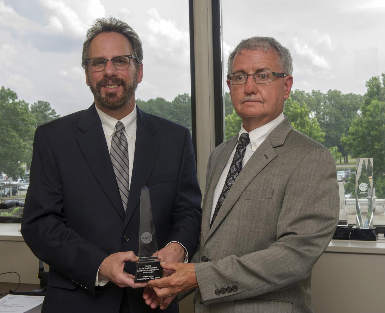 WALT MELTON AND DAVID BROCK OF PROCUREMENT DISPLAY THE FY’13 NASA SMALL BUSINESS PRIME SOCIOECONOMIC PRIME GOAL ACHIEVEMENT AWARD GIVEN TO THE CENTER FOR EXCEEDING ITS SMALL BUSINESS GOALS IN ALL SOCIOECONOMIC CATEGORIES.  MARSHALL IS THE ONLY NASA CENTER TO RECEIVE THE AWARD FOR FIVE CONSECUTIVE YEARS.
