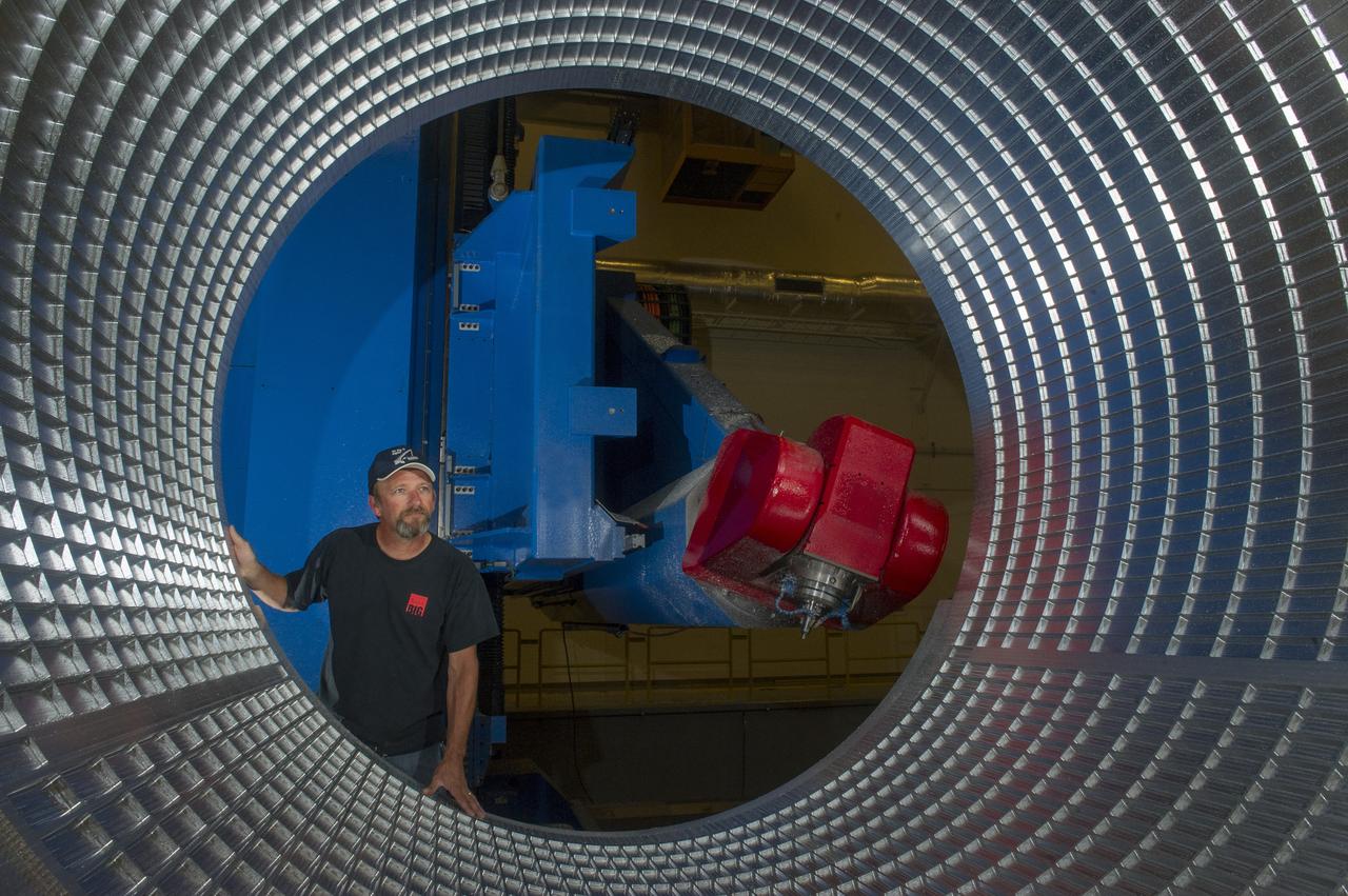 DAVID OSBORNE, A MACHINIST ON THE METTS CONTRACT, INSPECTS THE ORTHOGRID TOOL PATH ON AN 8 FOOT CF1 BARREL IN SUPPORT OF THE SHELL BUCKLING TEST FOR LANGLEY RESEARCH CENTER.  THIS IS THE FIRST BARREL THAT MSFC HAS MANUFACTURED FROM EXTRUDED MATERIAL, VERSUS THE ORIGINAL DESIGN BEING 3 SECTIONS BARREL PANELS THAT WERE FRICTION STIR WELDED.  THE TESTING WILL SHOW THE DIFFERENT STRENGTH PROPERTIES FROM A WELDED VERSION TO A FULLY EXTRUDED PIECE OF MATERIAL. 