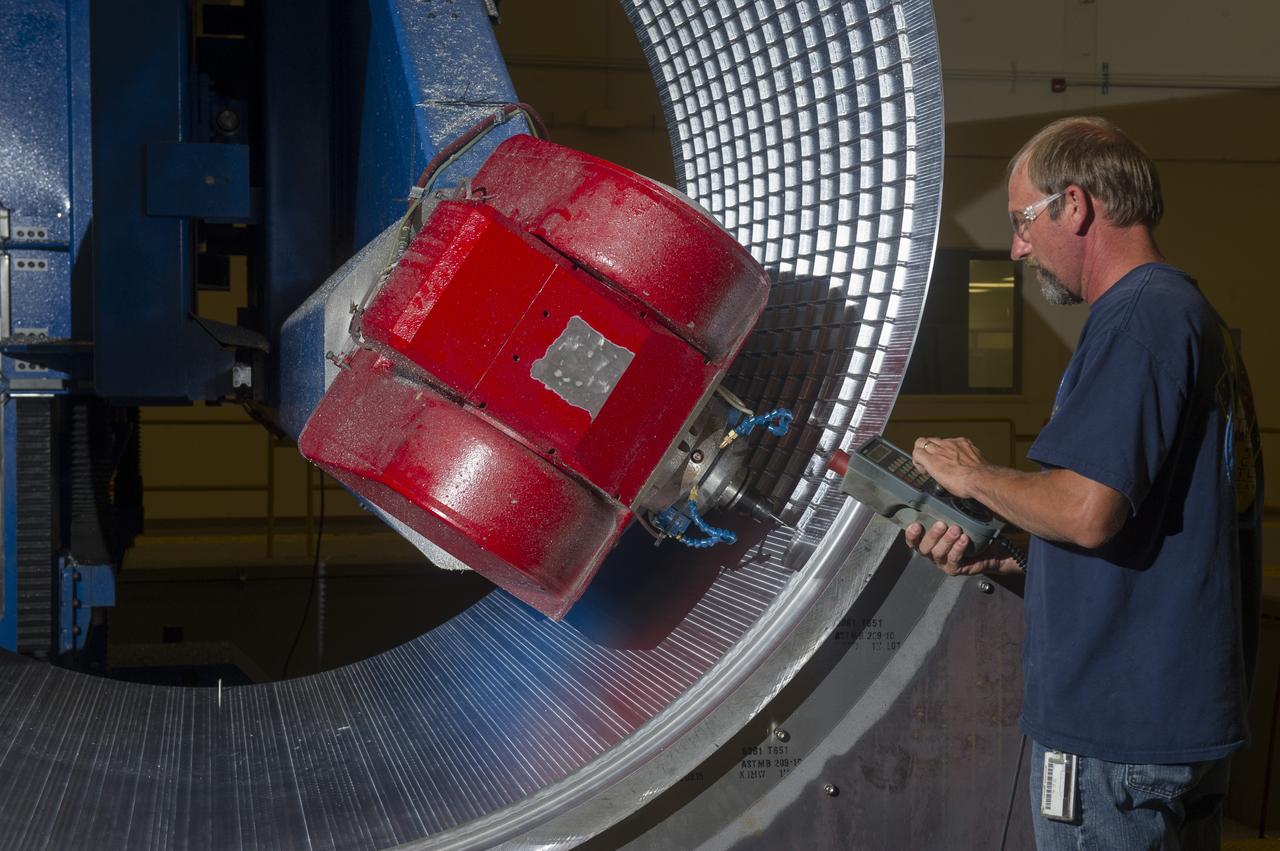 DAVID OSBORNE, A MACHINIST ON THE METTS CONTRACT, OPERATES THE 7-AXIS MILLING MACHINE WITH CF1 BARREL BEING PREPARED FOR SHELL BUCKLE TESTING