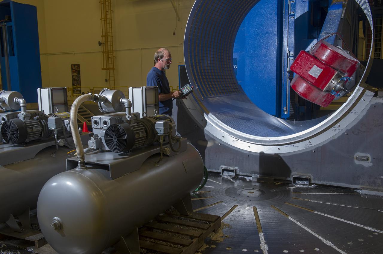 DAVID OSBORNE, A MACHINIST ON THE METTS CONTRACT, OPERATES THE 7-AXIS MILLING MACHINE WITH CF1 BARREL BEING PREPARED FOR SHELL BUCKLE TESTING