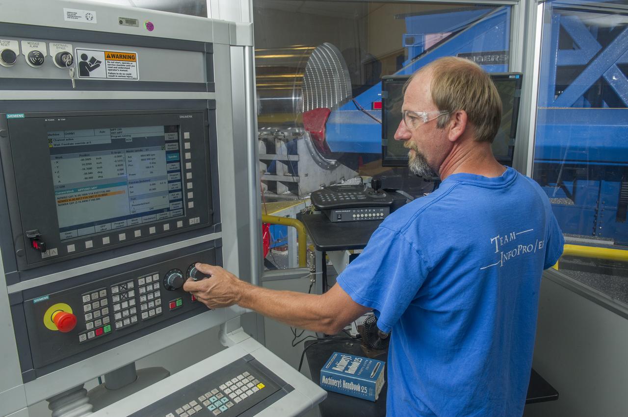 DAVID OSBORNE, A MACHINIST ON THE METTS CONTRACT, OPERATES THE 7-AXIS MILLING MACHINE WITH CF1 BARREL BEING PREPARED FOR SHELL BUCKLE TESTING