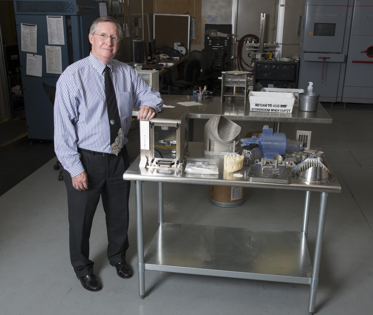 RAYMOND G. (CORKY) CLINTON WITH A WORKING MODEL OF THE FIRST 3-D PRINTER TO BE SENT TO THE ISS, ALONG WITH OTHER PRODUCTS FROM THE ADDITIVE MANUFACTURING LAB IN BUILDING 4707.