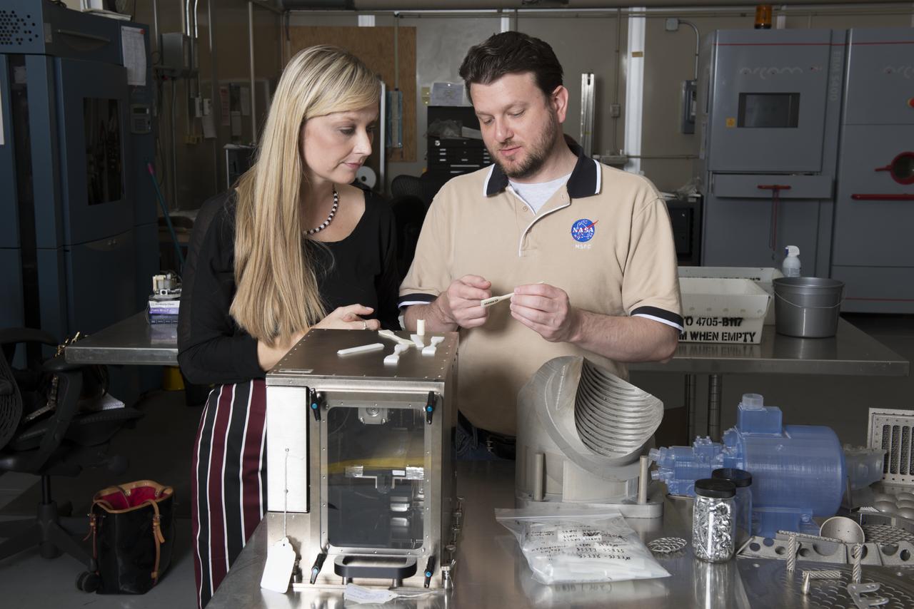 NIKKI WERKHEISER AND QUINCY BEAN, MEMBERS OF THE 3-D PRINTER TEAM EXAMINE PARTS PRODUCED ON A PROTOTYPE OF THE FIRST 3-D PRINTER TO BE SENT TO THE ISS