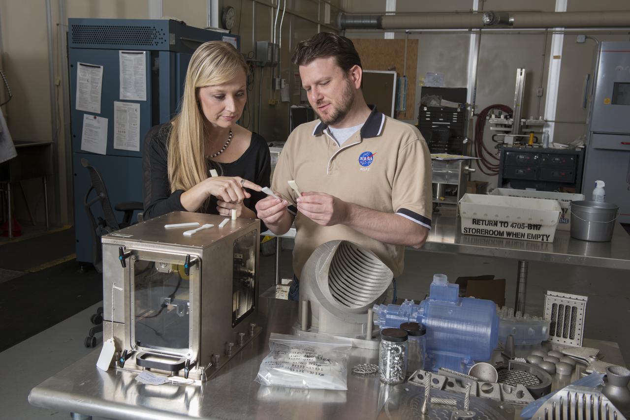 NIKKI WERKHEISER AND QUINCY BEAN, MEMBERS OF THE 3-D PRINTER TEAM EXAMINE PARTS PRODUCED ON A PROTOTYPE OF THE FIRST 3-D PRINTER TO BE SENT TO THE ISS
