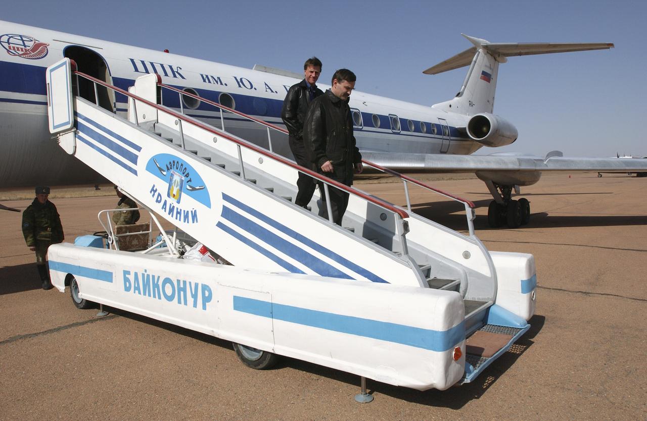 Astronaut Michael Foale, left, and Cosmonaut Alexander Kaleri, backup crew members for Expedition 7, depart the plane after their flight to Baikonur, Kazakhstan on Wednesday, April 9, 2003. The crews performed suit leak checks and Soyuz inspection, seat liner checks at the Baikonur Cosmodrome. Photo Credit: (NASA/Bill Ingalls)