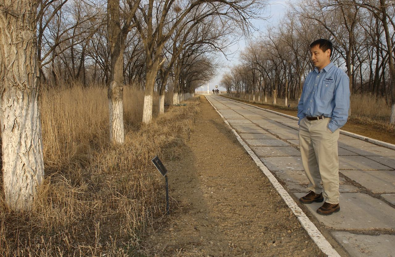 NASA International Space Station Science Officer and Flight Engineer for Expedition 7 Edward T. Lu, reads a marker placed in front of a tree planted in honor of cosmonaut Yuri Gagarin on the grounds of the Cosmonaut Hotel in Baikonur, Kazahstan on Wednesday, April 9, 2003. The trees along this walkway are planted in honor of other cosmonauts and astronauts. Photo Credit: (NASA/Bill Ingalls)