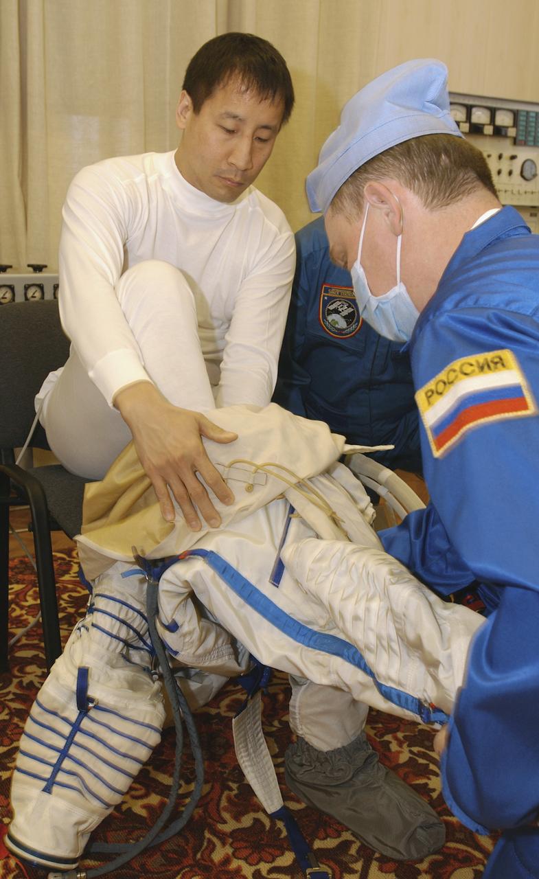 Astronaut Edward T. Lu, NASA International Space Station Science Officer and Flight Engineer for Expedition 7, dons his Russian Sokol suit for the leak check, seat liner check and Soyuz inspection at the Soyuz Integration Facility at the Baikonur Cosmodrome in Baikonur, Kazakhstan, Thursday, April 10, 2003. Photo Credit: (NASA/Bill Ingalls)