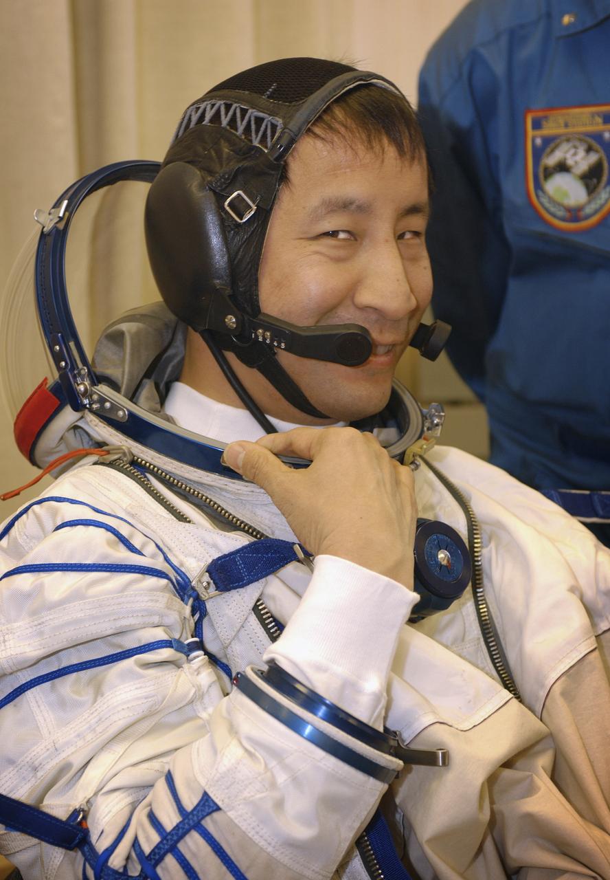 Astronaut Edward T. Lu, NASA International Space Station Science Officer and Flight Engineer for Expedition 7, dons his Russian Sokol suit for the leak check, seat liner check and Soyuz inspection at the Soyuz Integration Facility at the Baikonur Cosmodrome in Baikonur, Kazakhstan, Thursday, April 10, 2003. Photo Credit: (NASA/Bill Ingalls)