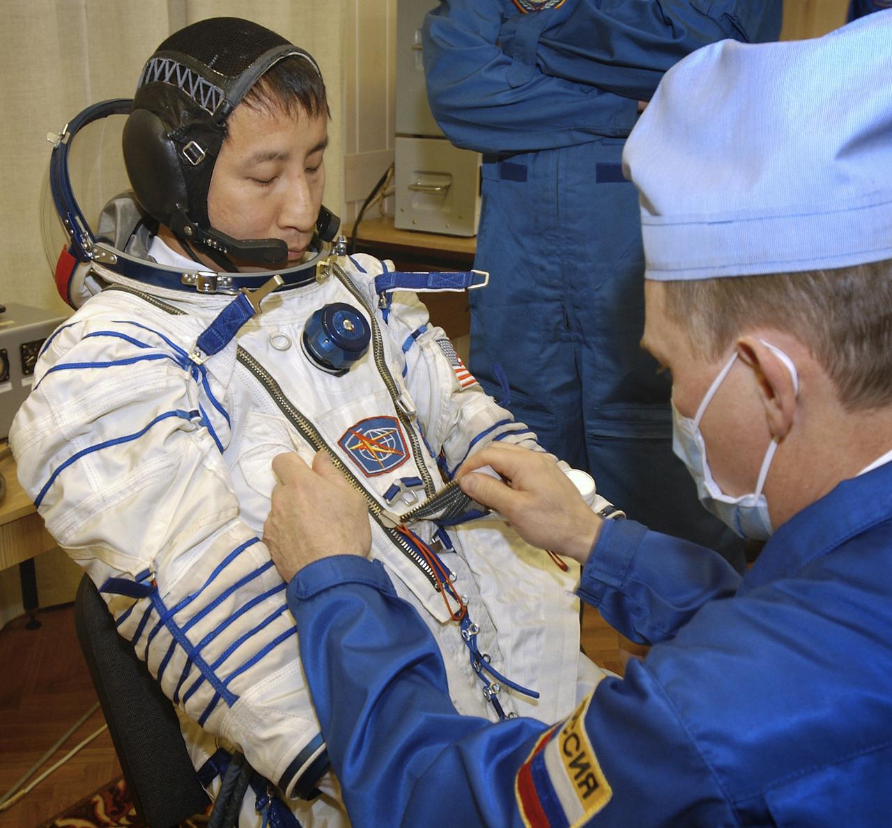 Astronaut Edward T. Lu, NASA International Space Station Science Officer and Flight Engineer for Expedition 7, dons his Russian Sokol suit for the leak check, seat liner check and Soyuz inspection at the Soyuz Integration Facility at the Baikonur Cosmodrome in Baikonur, Kazakhstan, Thursday, April 10, 2003. Photo Credit: (NASA/Bill Ingalls)