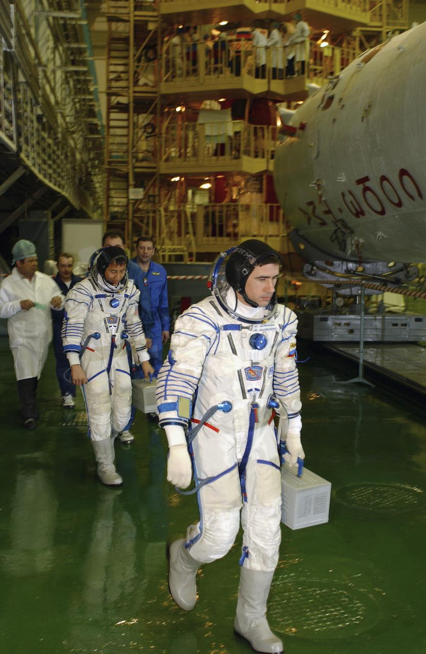Expedition 7 Commander Yuri I. Malenchenko, foreground and astronaut Edward T. Lu, NASA International Space Station Science Officer and Flight Engineer for Expedition 7, walk out for Soyuz inspection and seat liner check in the Soyuz Integration Facility at the Baikonur Cosmodrome, in Baikonur, Kazakhstan, Thursday, April 10, 2003. Photo Credit: (NASA/Bill Ingalls)