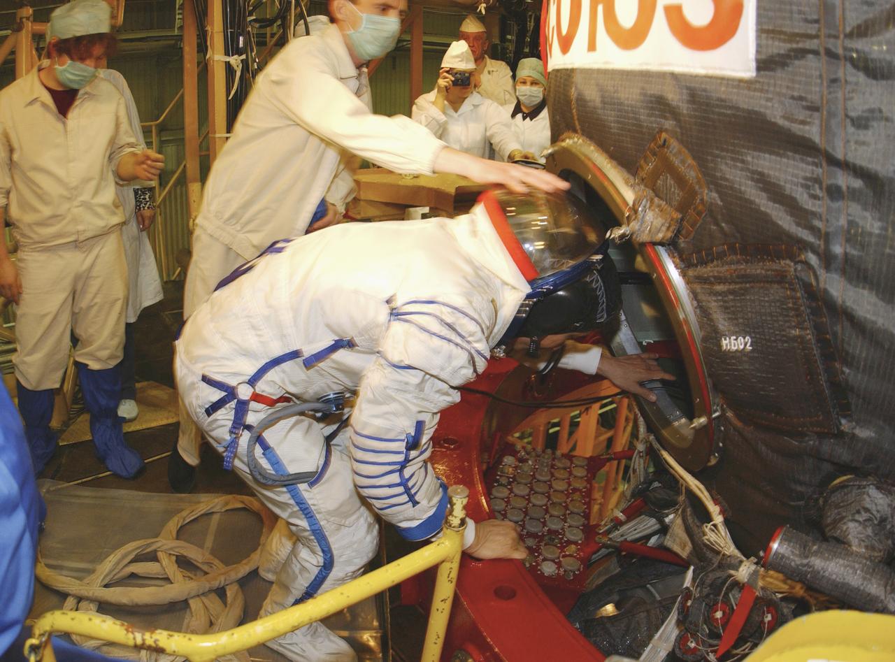 Edward T. Lu, NASA International Space Station Science Officer and Flight Engineer for Expedition 7, enters the Soyuz TMA-2 capsule for inspection and seat liner check in the Soyuz Integration Facility at the Baikonur Cosmodrome, in Baikonur, Kazakhstan, Thursday, April 10, 2003. Photo Credit: (NASA/Bill Ingalls)