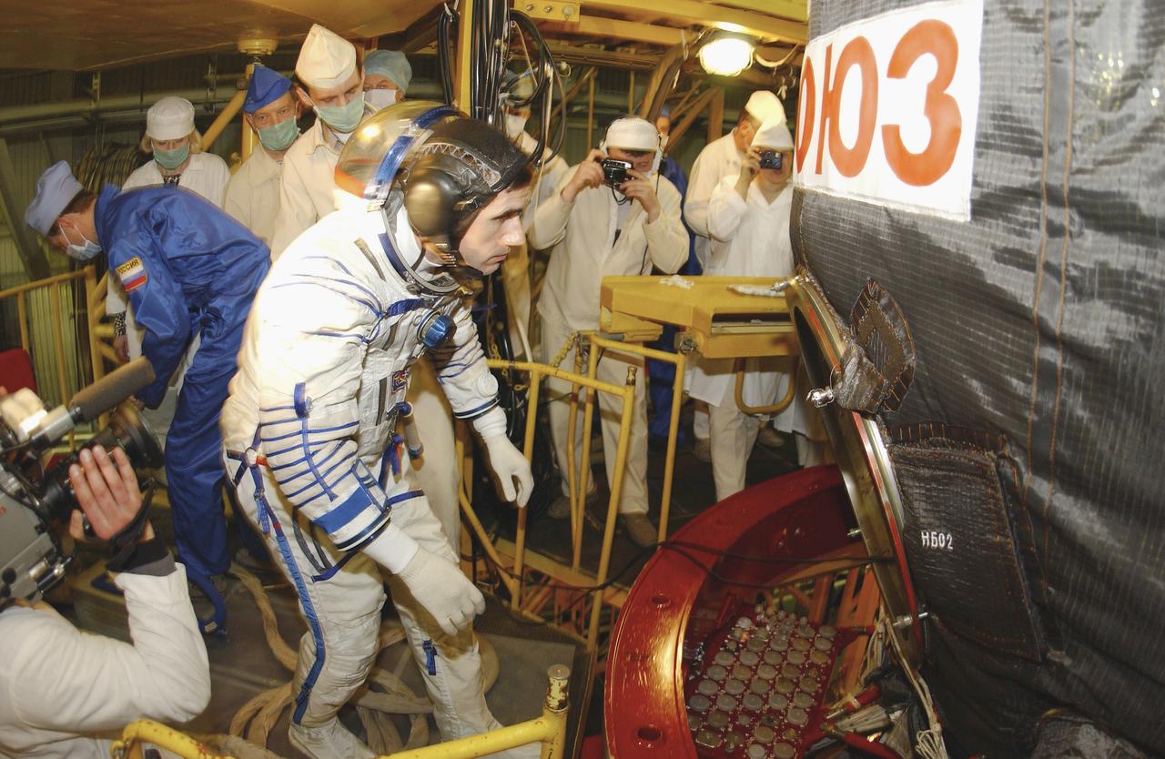 Expedition 7 Commander Yuri I. Malenchenko enters the Soyuz TMA-2 capsule for inspection and seat liner check in the Soyuz Integration Facility at the Baikonur Cosmodrome, in Baikonur, Kazakhstan, Thursday, April 10, 2003. Photo Credit: (NASA/Bill Ingalls)