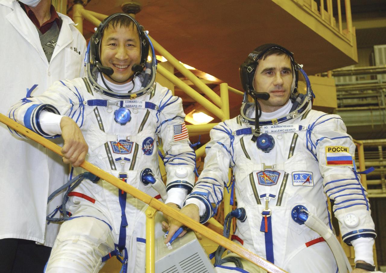 Astronaut Edward T. Lu, NASA International Space Station science officer and flight engineer for Expedition 7, left and Cosmonaut Yuri I. Malenchenko, Expedition 7 commander, pause for a photograph on the Soyuz stand after the Soyuz inspection and seat liner check at the Baikonur Cosmodrome, Building 254, Soyuz Integration Facility in Kazakhstan, Thursday, April 10, 2003. Photo Credit: (NASA/Bill Ingalls)