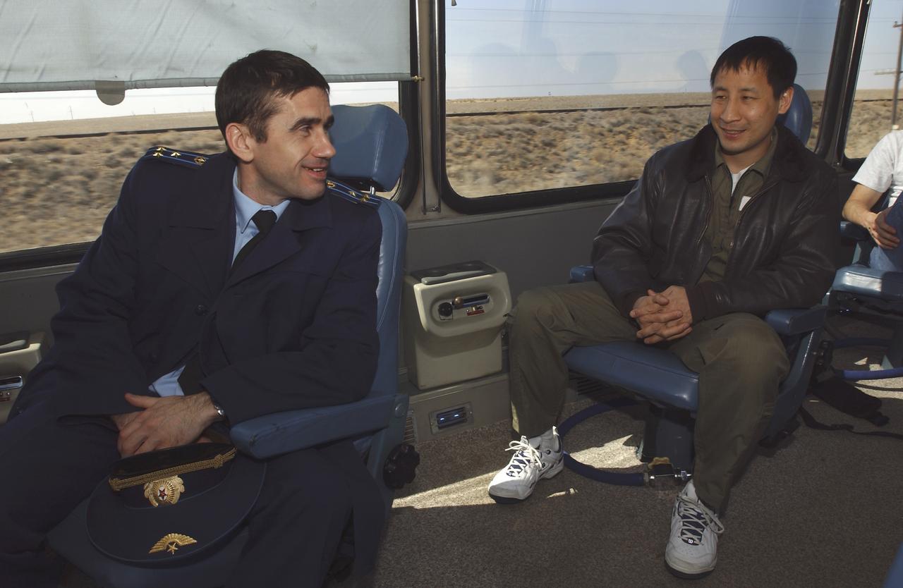 Cosmonaut Yuri I. Malenchenko, Expedition 7 commander, left and astronaut Edward T. Lu, NASA International Space Station science officer and flight engineer for Expedition 7, enjoying the bus ride back to the cosmonaut hotel after a busy day at the Baikonur Cosmodrome, Building 254, Soyuz Integration Facility in Kazakhstan, Thursday, April 10, 2003. Photo Credit: (NASA/Bill Ingalls)