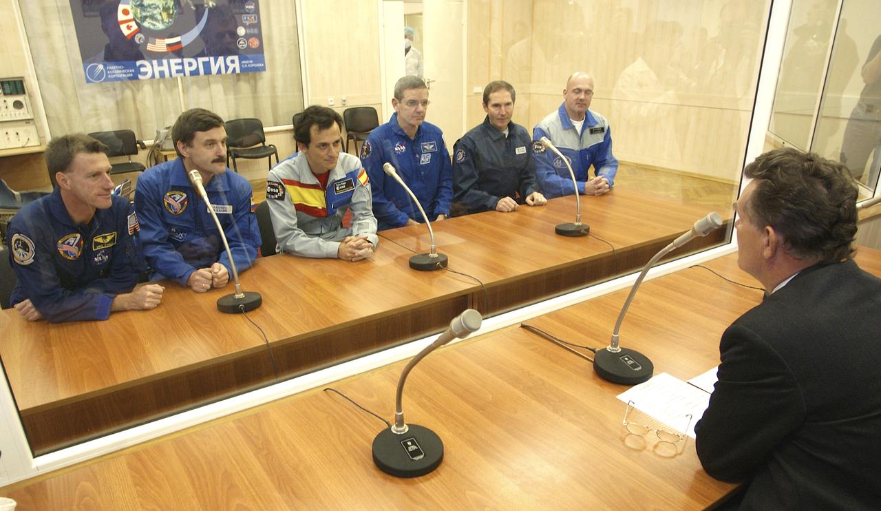 Expedition 8 ISS Commander and NASA Science Officer Michael Foale, far left, Expedition 8 Soyuz Commander and ISS Flight Engineer Alexander Kaleri and European Space Agency astronaut Pedro Duque of Spain, third from left, along with the backup crew (unidentified) are briefed by an official prior to a final inspection of the capsule in the complex' integration facility Monday, Oct. 13, 2003, at the Cosmodrome in Baikonur, Kazakhstan. Foale, Kaleri and Duque launched Oct. 18, 2003 aboard a Soyuz TMA-3 spacecraft enroute to the International Space Station. Photo Credit (NASA/Bill Ingalls)