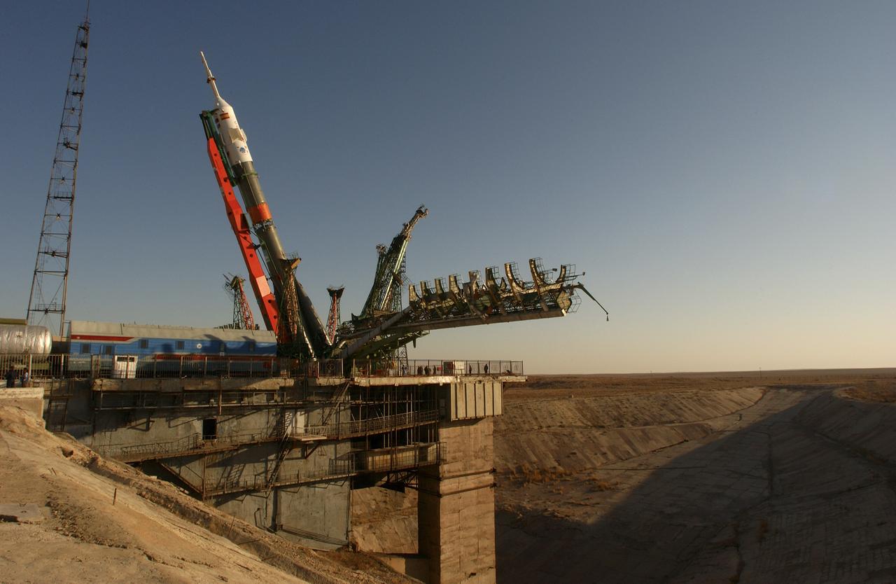 A Soyuz TMA-3 spacecraft and its booster rocket is raised, Thursday, Oct. 16, 2003, on the launch pad at the Baikonur Cosmodrome, Kazakhstan during preparations for liftoff Oct. 18 to carry Expedition 8 Commander and NASA Science Officer Michael Foale, Expedition 8 Soyuz Commander Alexander Kaleri and European Space Agency astronaut Pedro Duque of Spain to the International Space Station. Photo Credit (NASA/Bill Ingalls)