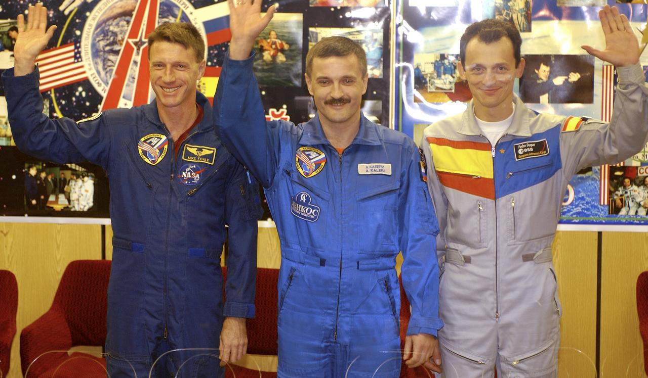 Expedition 8 Commander and NASA Science Officer Michael Foale, left, Expedition 8 Soyuz Commander Alexander Kaleri and European Space Agency astronaut Pedro Duque of Spain, right, wave to reporters at the conclusion of a prelaunch news conference, Friday, Oct. 17, 2003 in Baikonur, Kazakhstan. Photo Credit (NASA/Bill Ingalls)