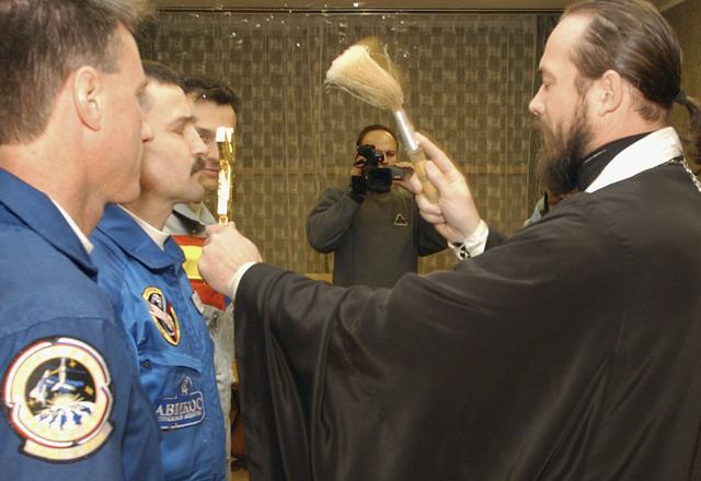 Expedition 8 Commander and NASA Science Officer Mike Foale, left, Expedition 8 Soyuz Commander Alexander Kaleri and European Space Agency astronaut Pedro Duque of Spain, receive a traditional blessing from an unidentified Russian Orthodox priest in their crew quarters at the Cosmonaut Hotel, Saturday, Oct. 18, 2003, in Baikonur, Kazakhstan prior to departing for the launch pad. Foale, Kaleri and Duque were launched on a Soyuz TMA-3 vehicle to the International Space Station, arriving on Oct. 20. Photo Credit (NASA/Bill Ingalls)